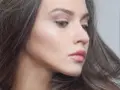 Delikatny makijaż glow podkreślający naturalne piękno. Skóra promienieje subtelnym blaskiem, a usta są muśnięte różowym błyszczykiem.