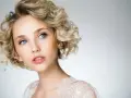 Blondynka z błękitnymi oczami i kręconymi włosami, prezentująca subtelny makijaż smoky eyes.