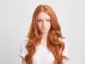 Dziewczyna z rudymi włosami, która zastanawia się nad wyborem niebieskiego szamponu na rude włosy.