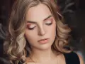 Delikatny makijaż na święta podkreśla urodę kobiety z blond włosami.