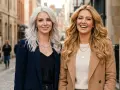 Dwie kobiety na ulicy. Jedna z platynowymi włosami, druga z ciepłym blondem, który idealnie pasuje do jej radosnego uśmiechu.