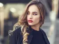 Blondynka z burzą falowanych włosów i wyrazistymi, czerwonymi ustami. Idealny kolor pomadki dla blondynek podkreśla jej urodę.