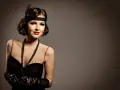 Elegancka kobieta w stylu lat 20. z charakterystycznym makijażem, opaską na głowie i czarną suknią.