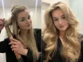 Jak zrobic loki bez lokówki? Blondynka kręci włosy prostownicą, a potem prezentuje efekt - piękne fale.