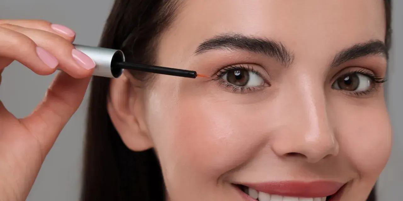 Kobieta aplikuje serum z bimatoprost na brwi, by uzyskać gęstszy efekt.