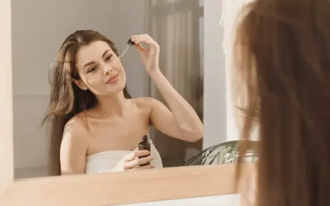 Kwas azelainowy z czym nie łączyć? Kobieta aplikuje serum na twarz, dbając o cerę.