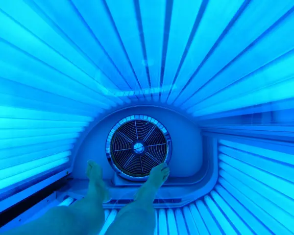 Nogi w solarium. Czy 10 minut na solarium to ile to na słońcu? Intensywne niebieskie światło lamp.
