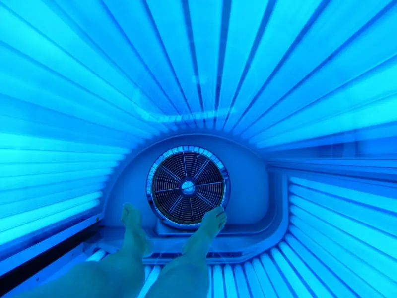 Nogi w solarium. Czy 10 minut na solarium to ile to na słońcu? Intensywne niebieskie światło lamp.